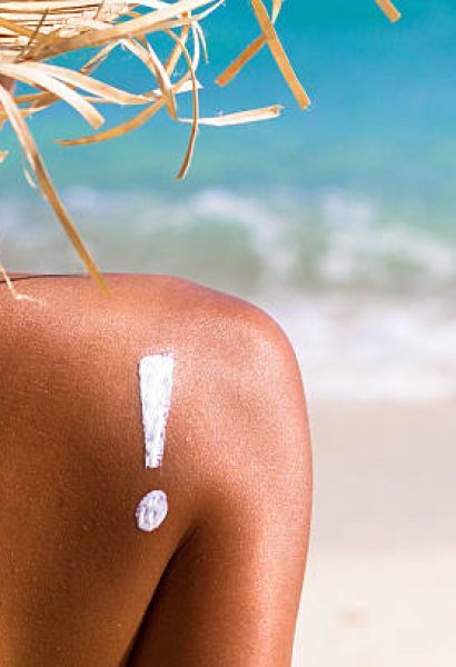 young woman on beach with suntan lotion young woman on beach with suntan lotion